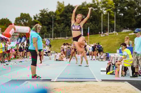 Mladý atlét predvádza gymnastické cvičenie na karimatke