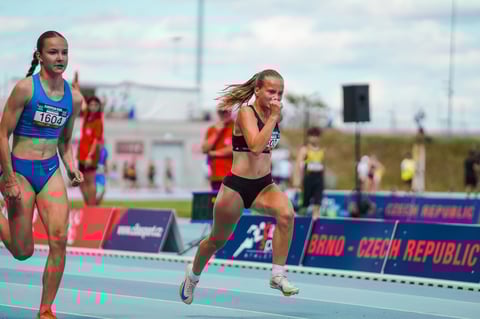 Mladé atlétky bežia na dráhe